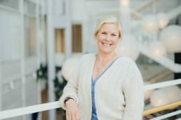 Dame i hvit genser og blå bluse.