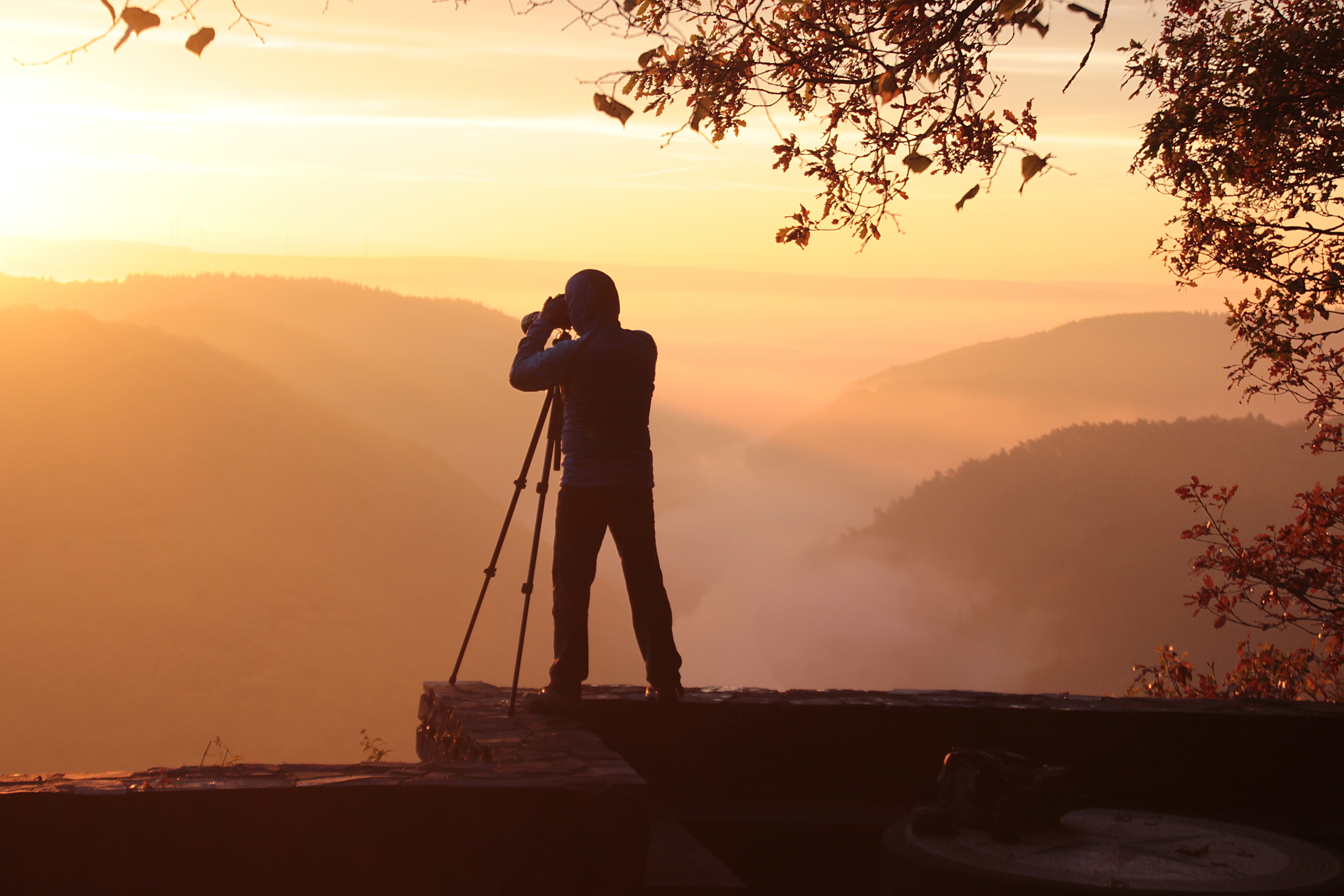 Mann fotograferer et landskap med fjelltopper