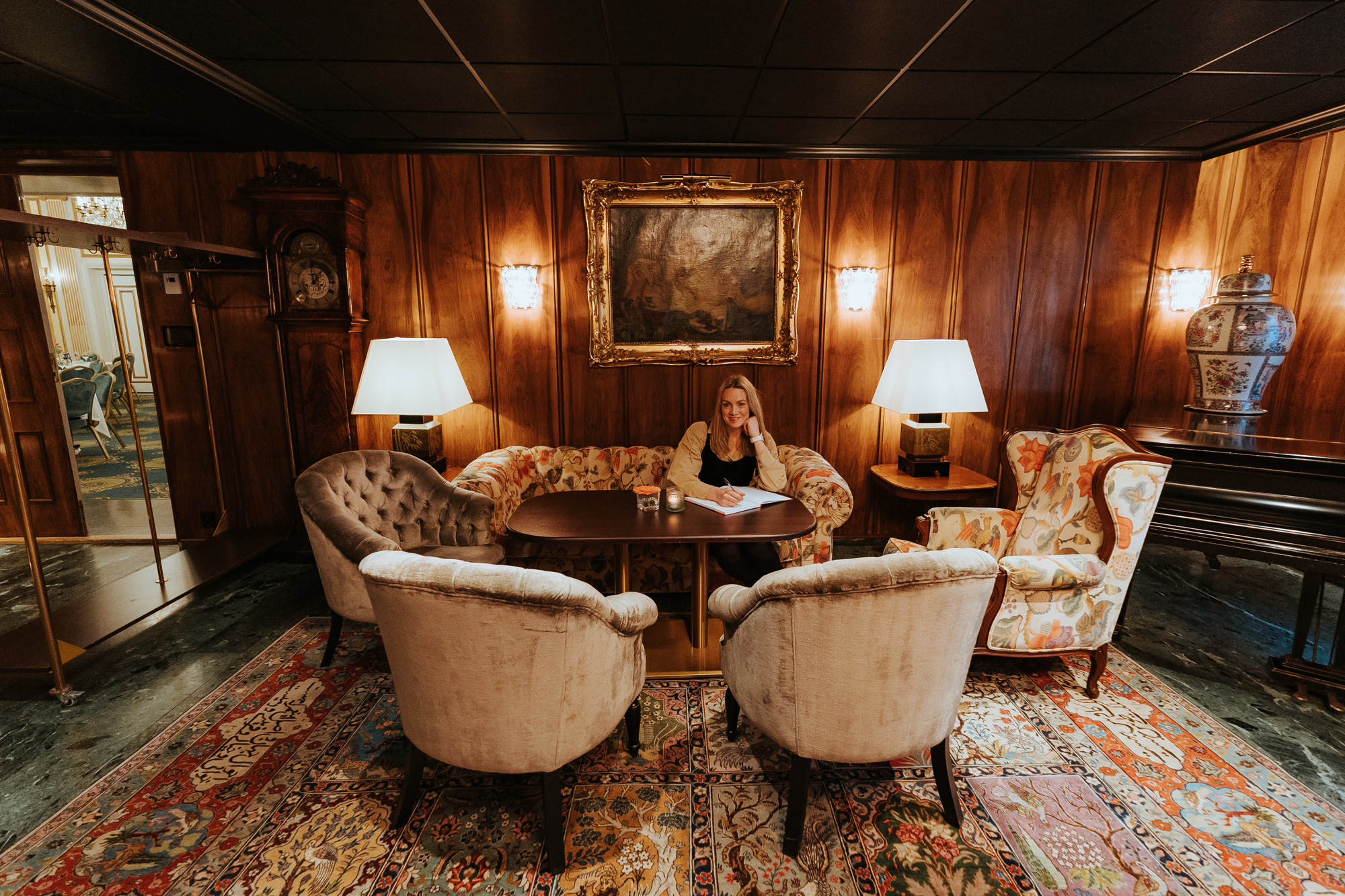 Ingvild sitter i en sofa på Hotel Bristol og skriver.