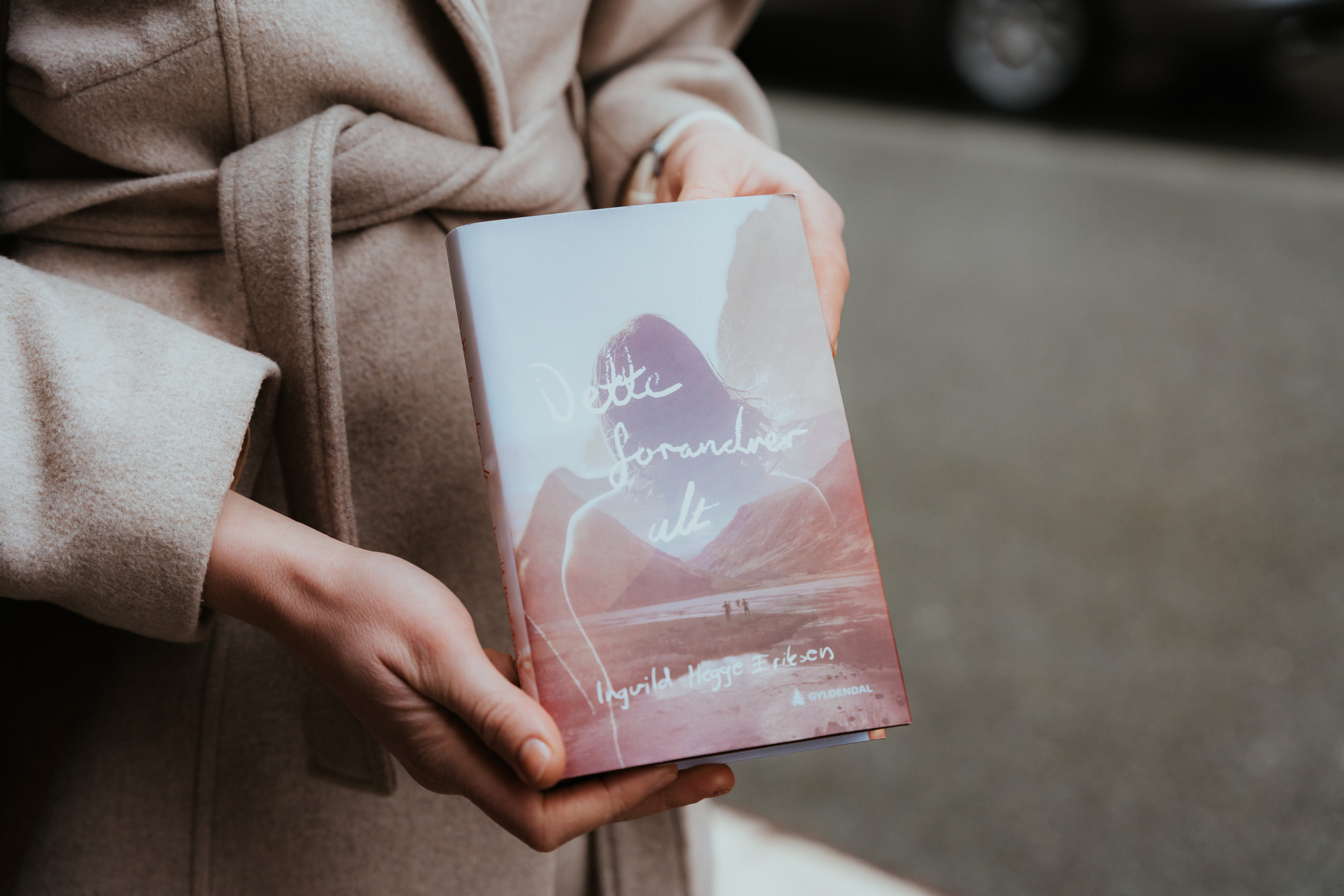 Nærbilde av romanen til Ingvild mens hun holder den i hendene. 