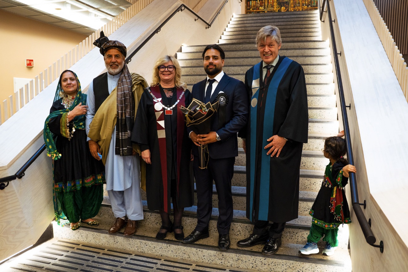 Rektor Trine J. Meza og prorektor Jens Barland med avgangsstudent Shamstad Rodwa og familien hans.