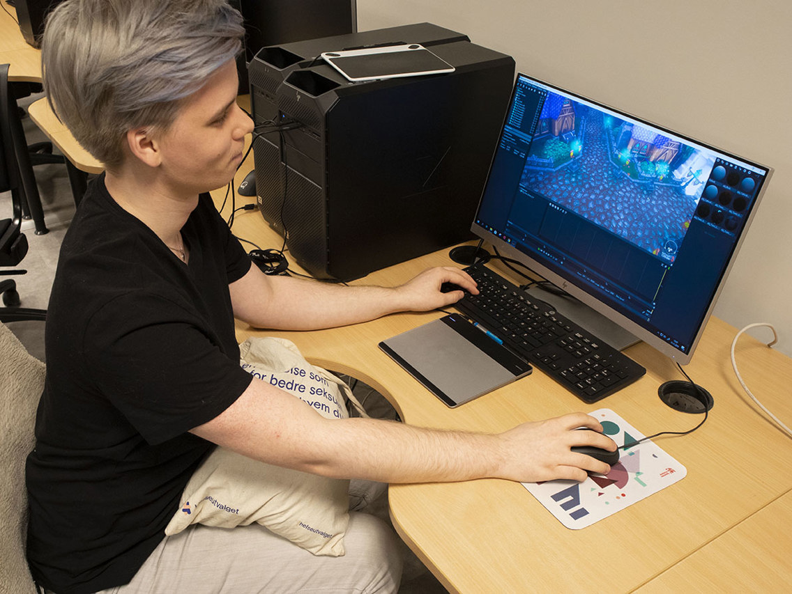 Sindre lie sitter foran dataskjerm og viser hvilke programvarer han bruker når han jobber