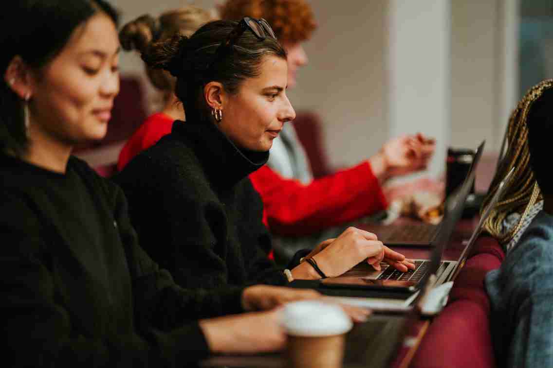 Flere studenter som studerer sammen i et auditorium. 