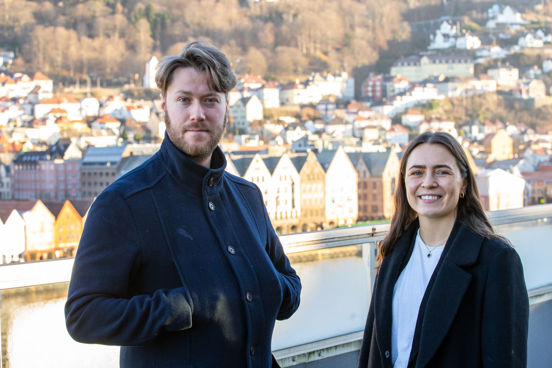 Anders og Ida på en takterasse, i bakgrunnen ser vi Bryggen i Bergen.