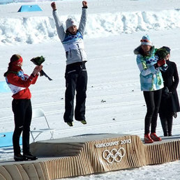Kvinne som jubler på pallen etter å ha tatt OL-gull på ski.