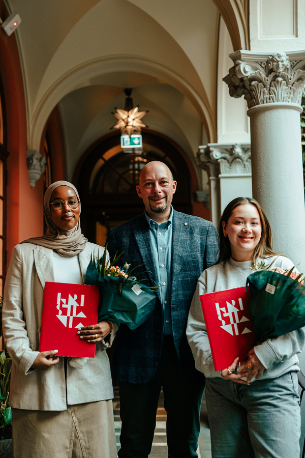 To studenter og en dekan i forbindelse med stipendutdeling. 