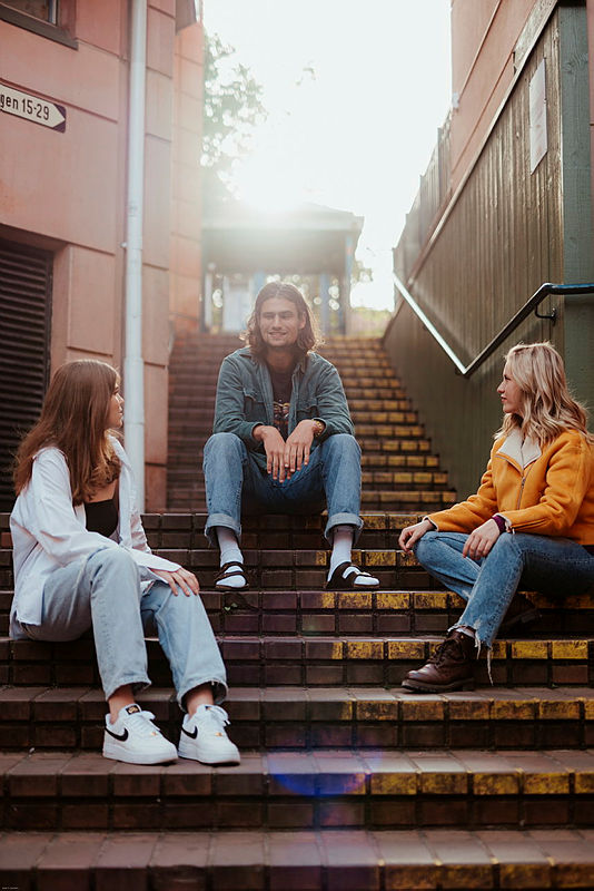 Bilde av tre studenter sittende i en trapp
