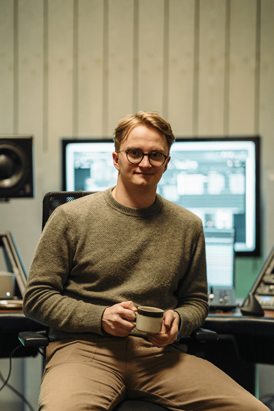 Herman Hassel smiler til kamera foran miksebordet. 