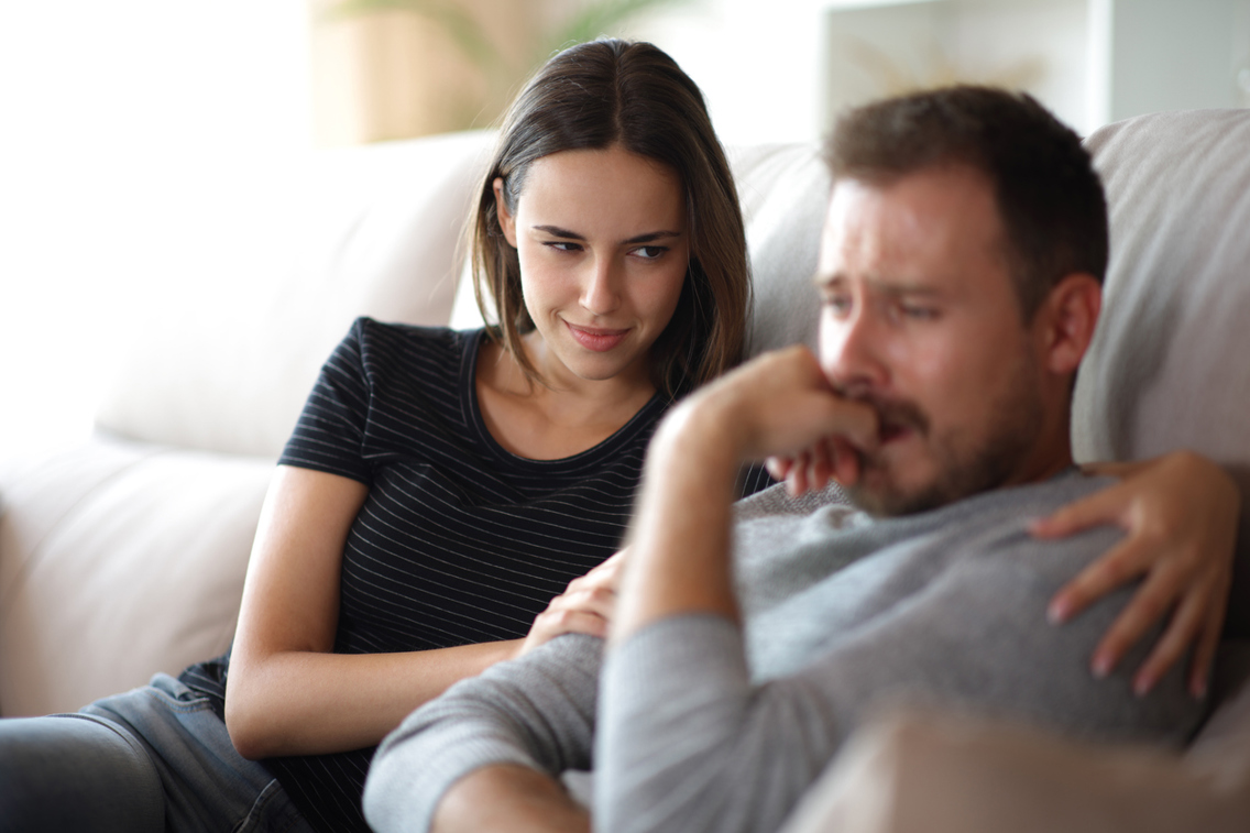 En kvinne ser lurt på en mann som er lei seg