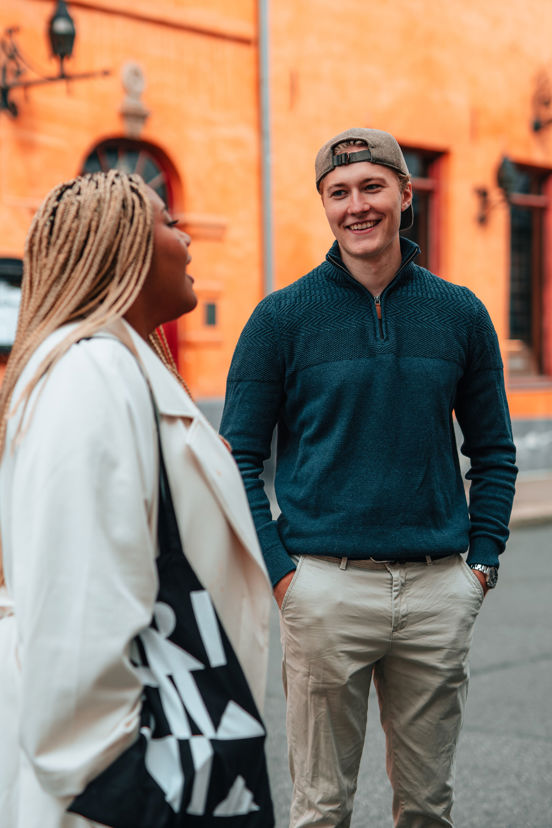 To studenter snakker sammen ute på et fortau.