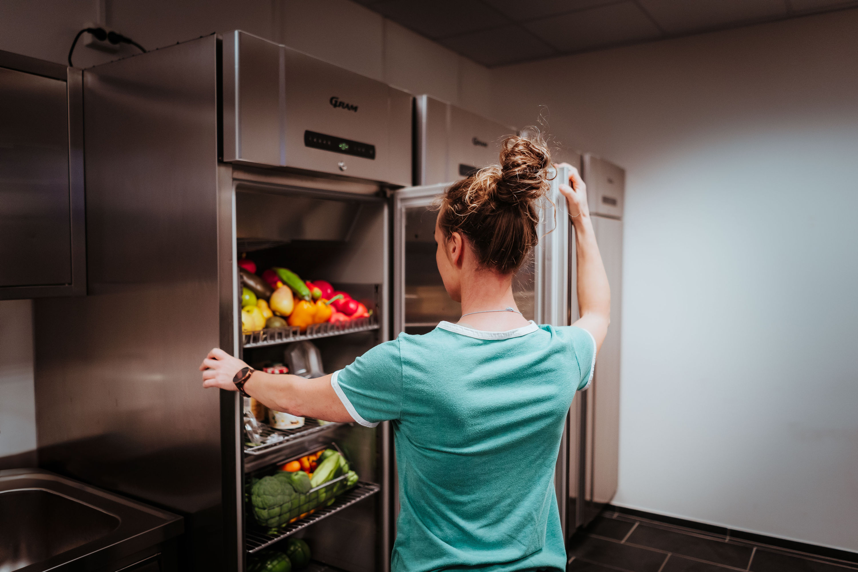 Ditta har åpnet et kjøleskap som bugner av frukt og grønt.