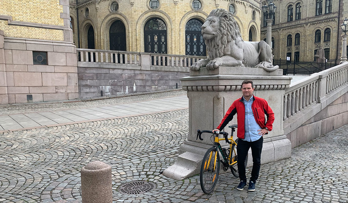 Bilde: Mann med sykkel foran Stortinget.