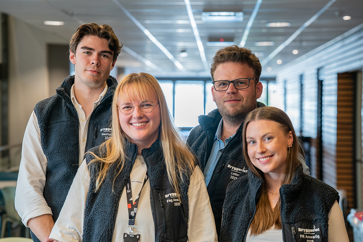 Fire mennesker smiler til kamera.