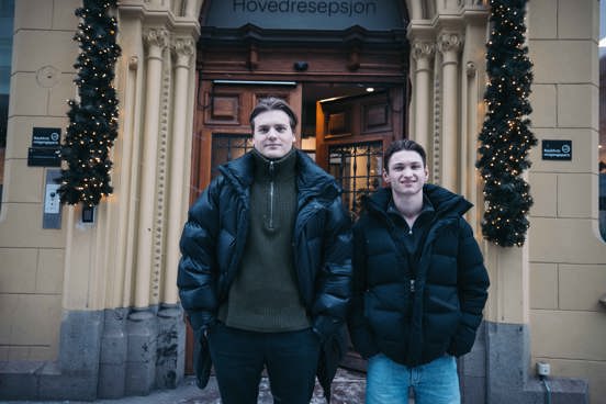 Foto av Krisander Østlie og Jens Petter Iversen foran en inngangsdør.