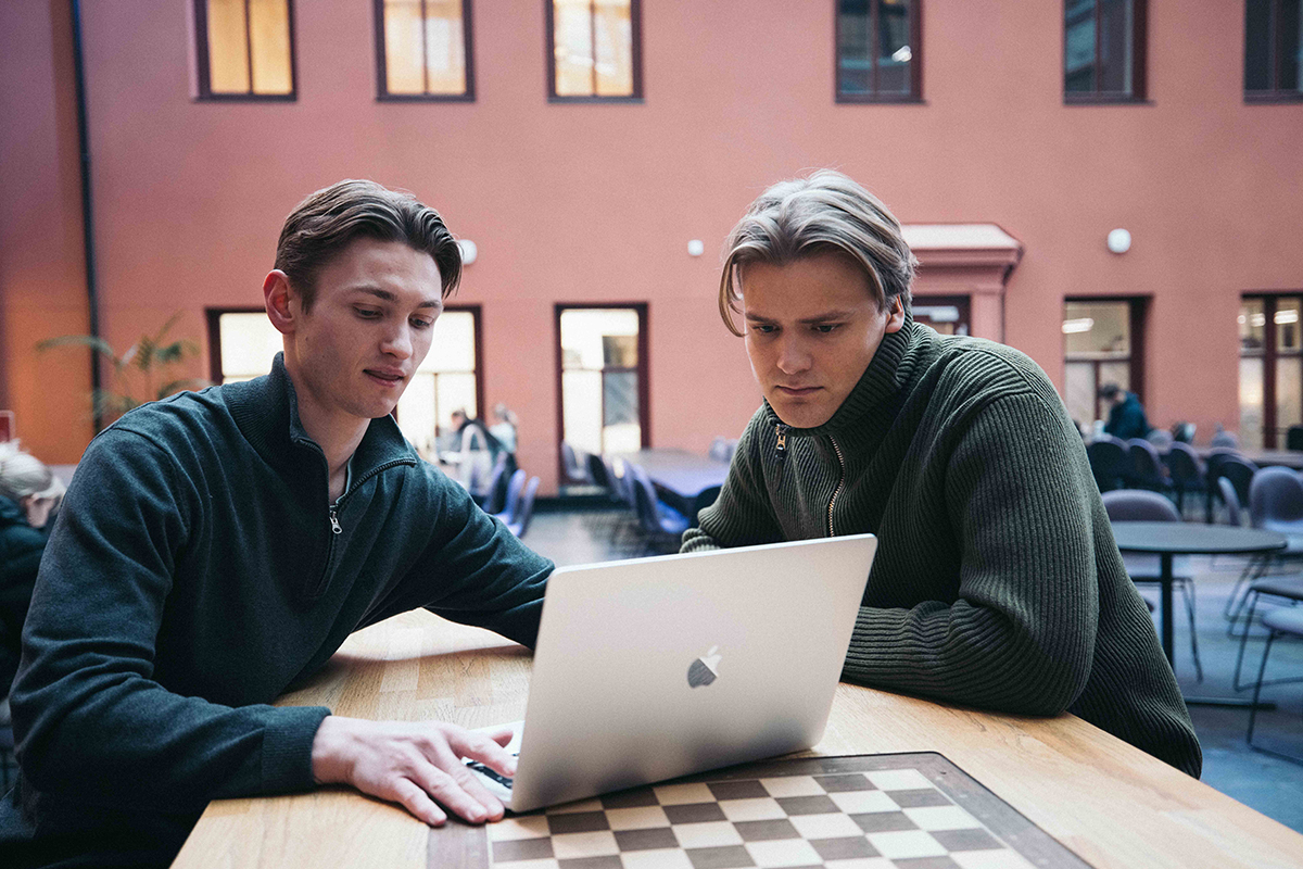 Krisander Østlie og Jens Petter Iversen ser sammen på en PC.
