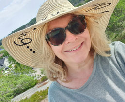 Foto av kvinne med stråhatt og solbriller.