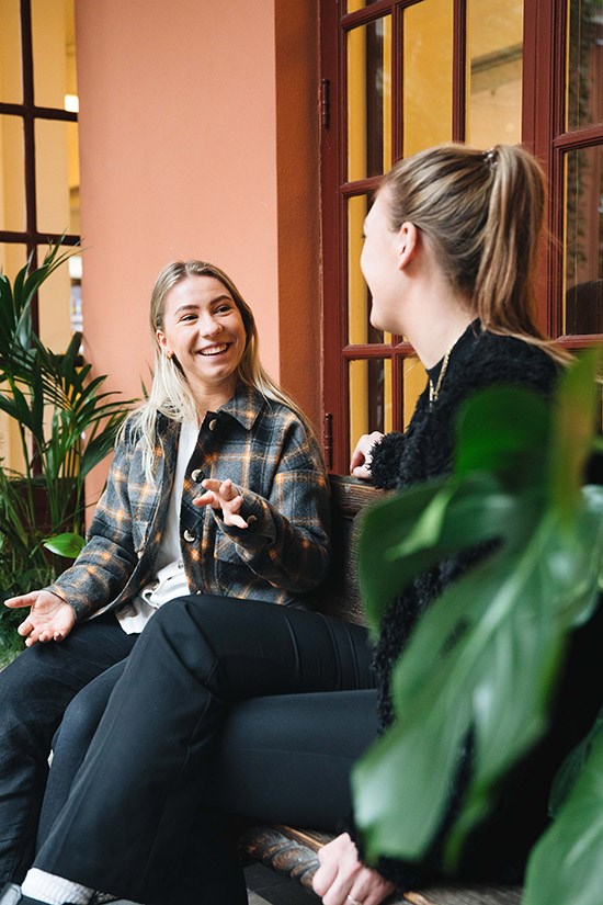 Karine og Camilla Uvaag er avbildet på kvadraturen. De sitter mot hverandre og diskuterer.