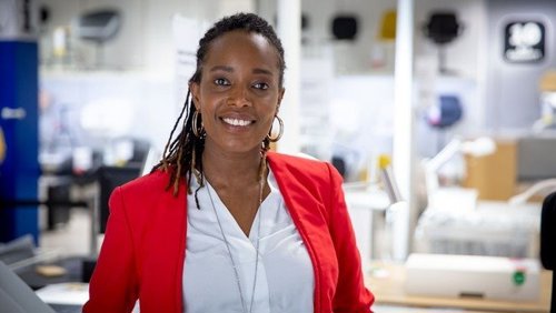 Francine Mbanza Jensen smiler til fotografen i et NRK-studio
