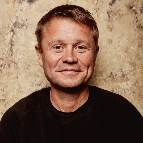 Martin Eia-Revheim smiler lurt til kamera. Han har svart genser og kort, mellomblondt hår.