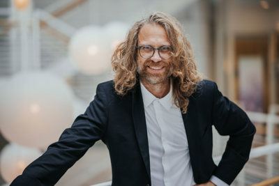 Mann med briller og krøllete crazy hår.