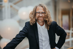 Mann med briller og krøllete crazy hår.