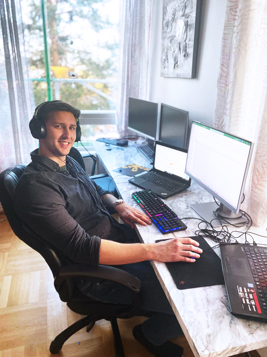 Foto av Jørgen Melgaard, student på master i Information Systems - Management and Innovation. Han sitter på hjemmekontor med PC-skjermer foran seg.