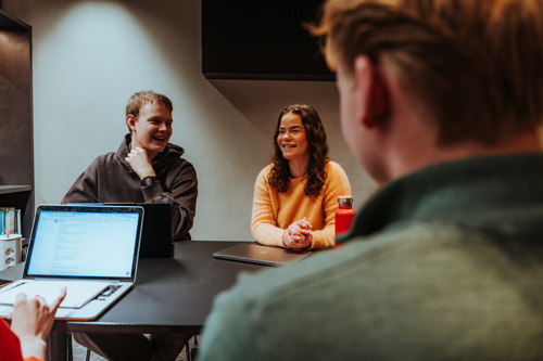 Studenter i grupperom jobber med PC-er.