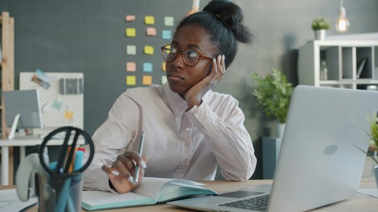 Woman sitting with post-it notes on her wall in front of her tv thinking