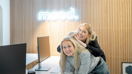 To personer sitter sammen på kontoret hos Mood