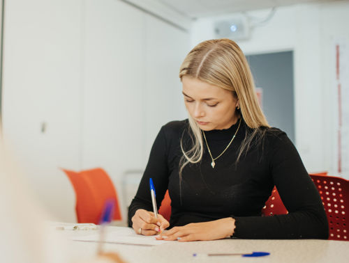 Student skriver med penn.
