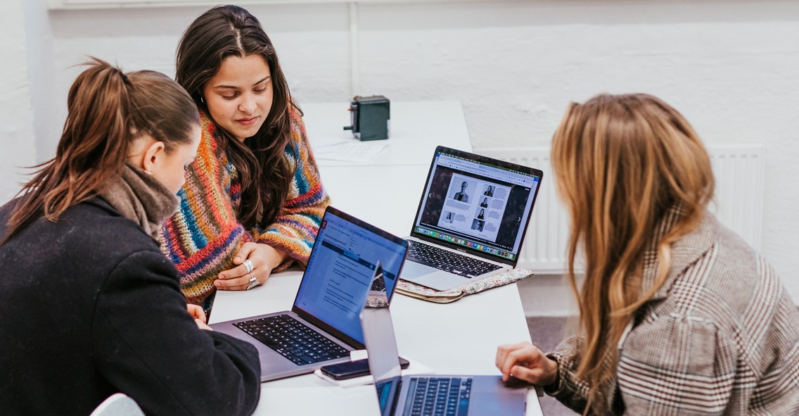 Tre studenter jobber på PC