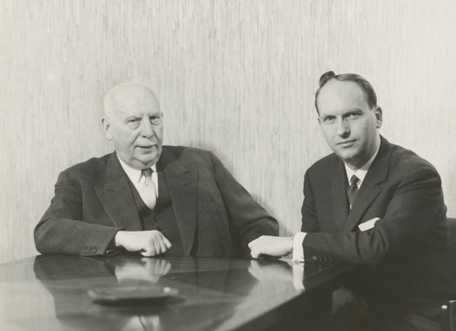 Bilde av en eldre mann og en middelaldrende mann, begge i dress med litt høytidelige uttrykk.