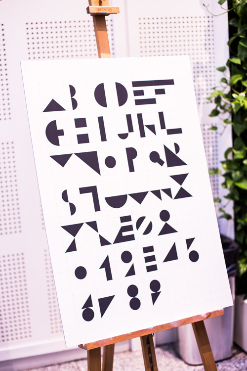 En plakat viser et nytt alfabet laget av former som trekanser, buer og rektangler. 