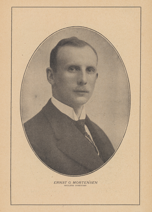 En alvorlig ung mann i dress stirrer inn i kameraet.